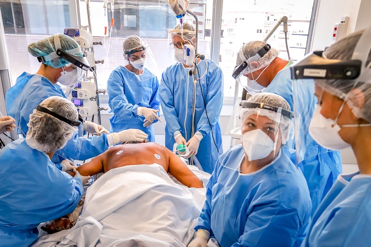 PORTO ALEGRE, BRAZIL - JANUARY 07: Clinicians manually prone a COVID-19 patient in the Intensive Care Unit (ICU) at the Hospital de Clinicas de Porto Alegre on January 7, 2021 in Porto Alegre, Brazil. The Hospital de Clinicas de Porto Alegre is a public institution and since the beginning of the coronavirus pandemic, it has treated 1,400 critically ill patients at the Intensive Care Unit. To meet the demand, they had to install 105 new beds and temporarily hire 775 professionals, in addition to recruiting volunteers. Brazil has registered over 7.8 million confirmed cases of the virus since the pandemic began, while the official death toll from COVID-19 is nearing 200,000, the second highest in the world. (Photo by Silvio Avila/Getty Images)