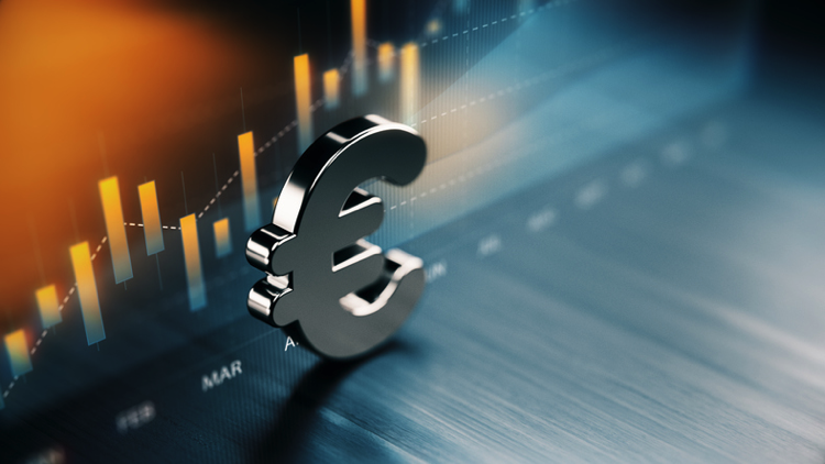 European Union Currency Symbol Standing On Wood Surface In Front Of A Graph