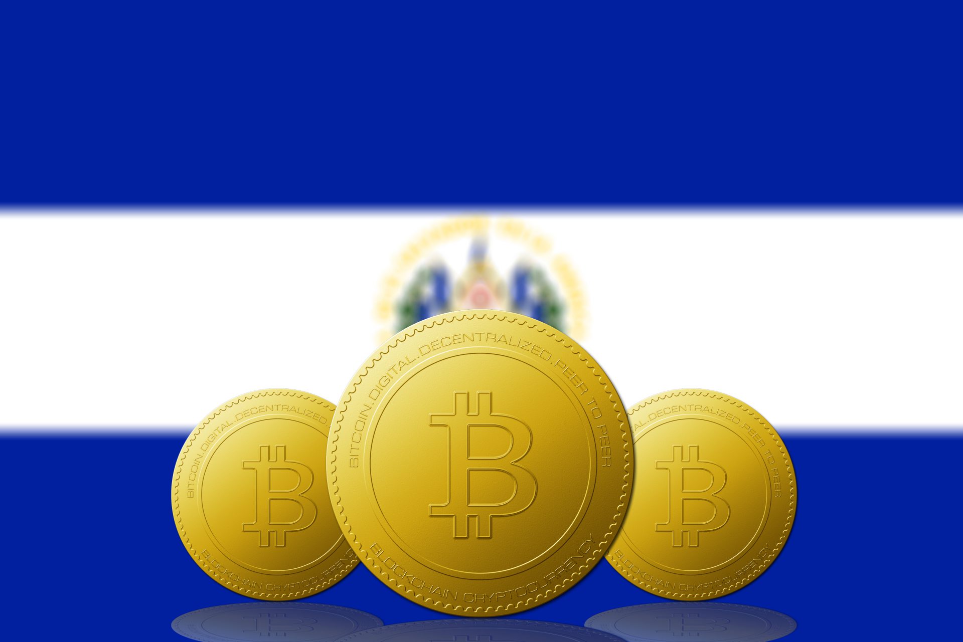 Three Bitcoins cryptocurrency with El Salvador flag on background.