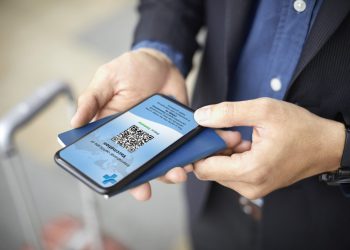 Executive with online Covid-19 Vaccine Passport On phone