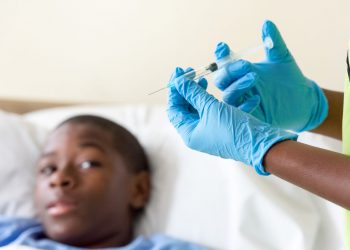 Teenage boy awaits shot from doctor