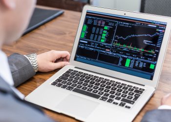 Young businessman analyzing economic data on laptop computer.