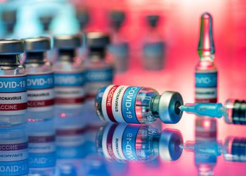 Close-up of vials and syringe in a laboratory - Covid-19 vaccine research