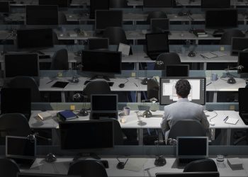 An office worker sits working in an empty office
