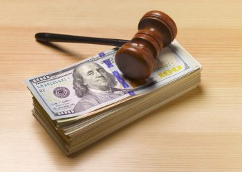 judges/auctioneer's gavel with a pile of dollars