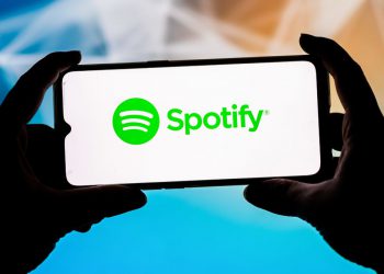 In this photo illustration a Spotify logo seen displayed on