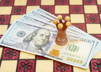 Business and success concept. On the chessboard there is money on which the red king stands.