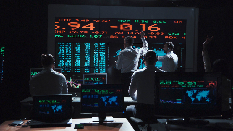 Two stock broker team leaders in front of a live, futuristic global market feed.