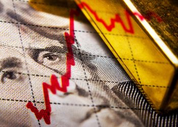 Close up of a dollar banknote and gold ingot and a financial chart