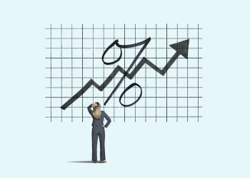 A woman looks up at an arrow and an interest rate symbol amidst as rates start to rise.