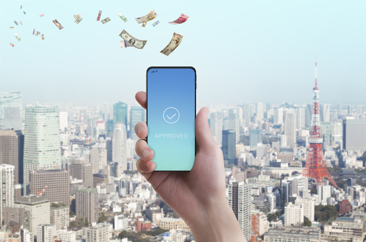 Mobile payment. Woman's hand has smartphone with banknote in the sky.