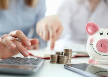 Man and woman hand consider on calculator expenses of family budget aganist home background. Lending purchase rental housing mortgage concept