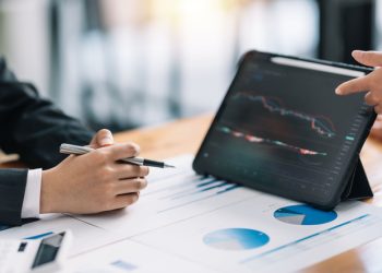 Investor team analyzes the stock market on a tablet at the meeting.