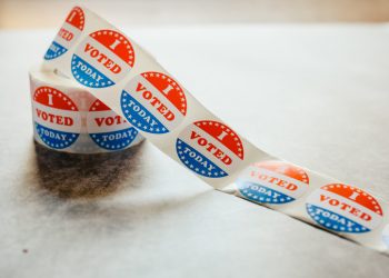 Roll of "I voted" circular stickers on a gray background for the November elections in the United States.