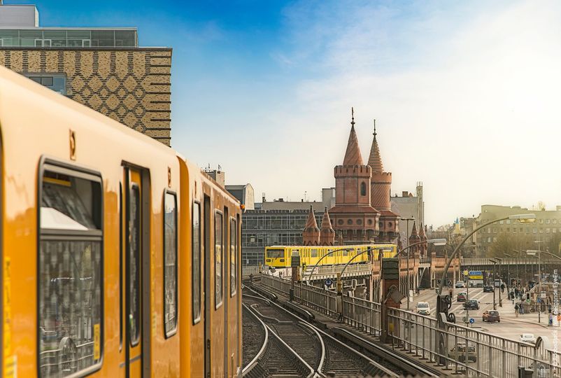 Panoramic view of Berliner U-Bahn trains with Oberbaumbridge in the background in golden evening light at sunset, Berlin Friedrichshain-Kreuzberg, Germany