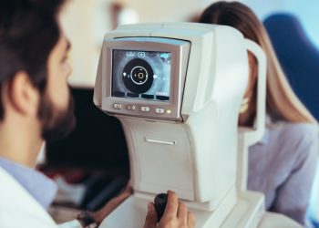 Optometrist checking patient eyesight and vision correction