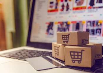 Shopping online concept - Shopping service on The online web. with payment by credit card and offers home delivery. parcel or Paper cartons with a shopping cart logo on a laptop keyboard
