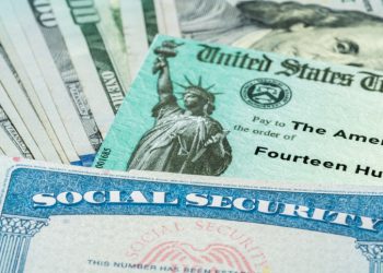 Stack of 100 dollar bills with US Treasury illustrative check to illustrate American Rescue Plan Act of 2021 payment with social security card for retirees