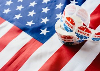I vote today stickers roll, in US elections on American flag.