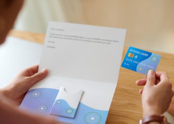 Woman reading letter from bank, containing credit card and personal loan offer information
